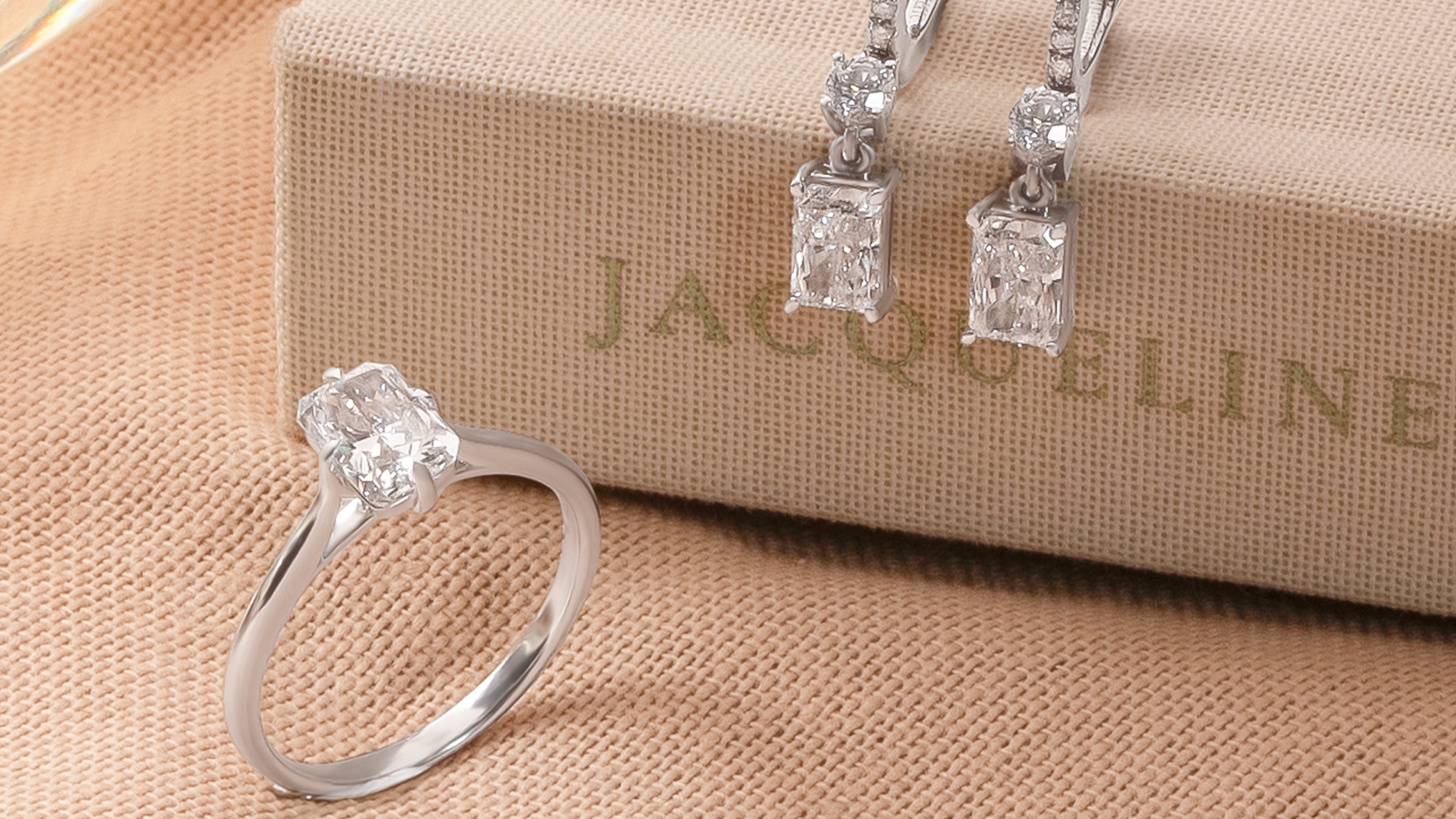 Diamond ring and earrings on a beige surface with 'Sol et Terre' branding.