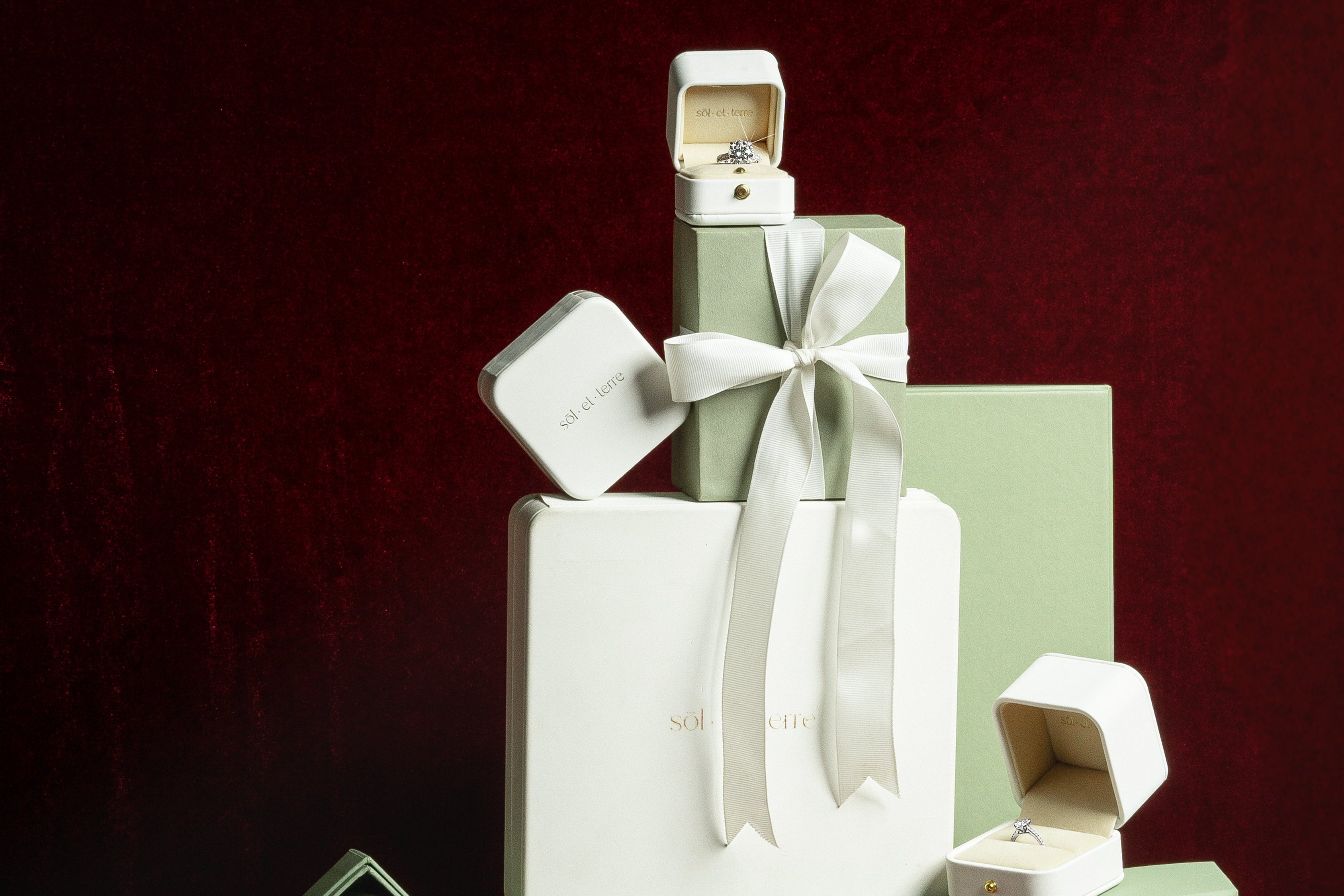 Stack of green and white boxes with 'sol el terre' branding on a dark red background